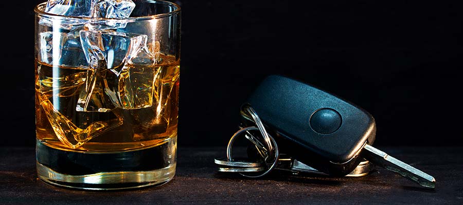стакан с алкоголем и ключи от машины на столе